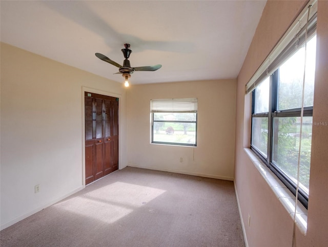 carpeted spare room with ceiling fan