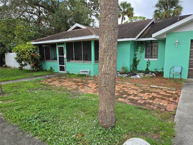 ranch-style home with a front lawn and a sunroom