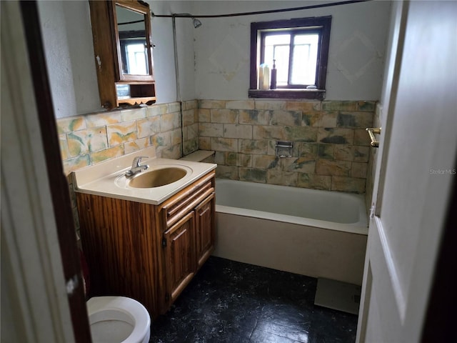 bathroom with toilet, vanity, a wealth of natural light, and a bathtub