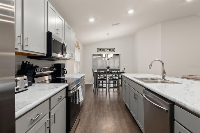 kitchen featuring stainless steel appliances, pendant lighting, sink, dark wood-type flooring, and lofted ceiling