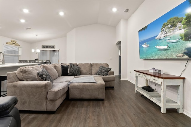 living room featuring a notable chandelier, dark hardwood / wood-style floors, sink, and vaulted ceiling