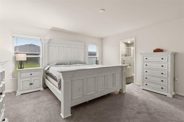 carpeted bedroom with ensuite bathroom and multiple windows