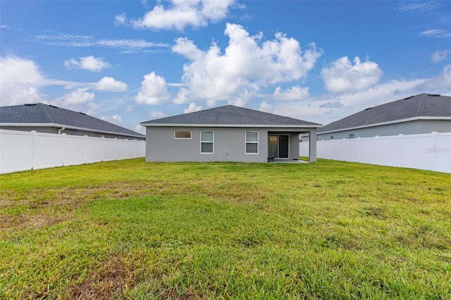 rear view of house featuring a yard