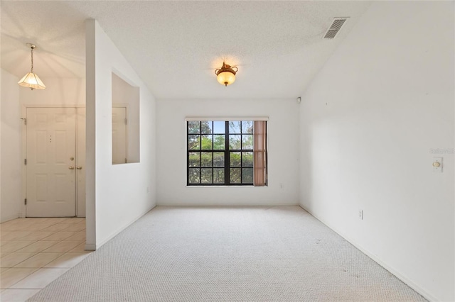 empty room with light colored carpet and a textured ceiling