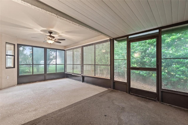 unfurnished sunroom featuring ceiling fan and plenty of natural light