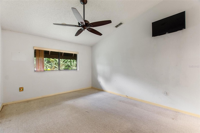 empty room featuring lofted ceiling, a textured ceiling, carpet, and ceiling fan