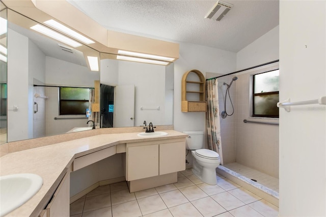 bathroom featuring lofted ceiling, toilet, tile patterned flooring, a textured ceiling, and vanity