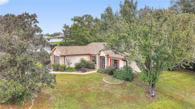 view of property hidden behind natural elements featuring a front lawn