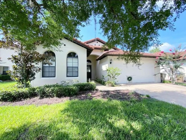 mediterranean / spanish-style house with a garage and a front yard