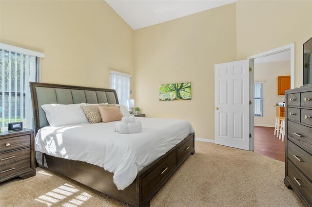 carpeted bedroom featuring high vaulted ceiling