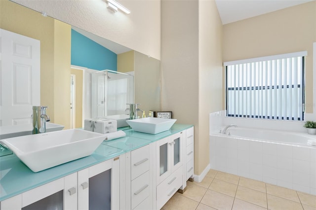 bathroom with lofted ceiling, independent shower and bath, vanity, and tile patterned floors