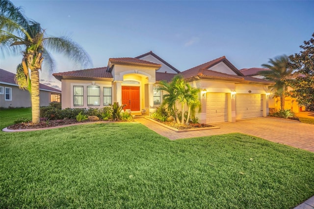 mediterranean / spanish-style house with a garage and a lawn