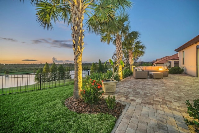 yard at dusk featuring a patio and outdoor lounge area