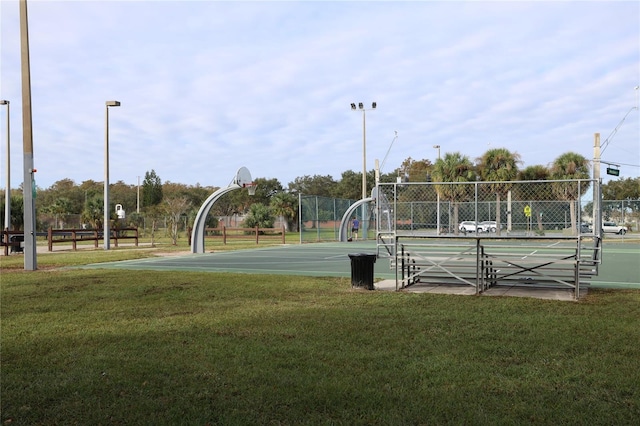 view of community with a lawn and basketball hoop