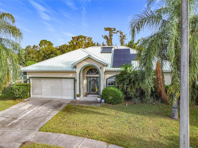 view of front of house with a front lawn, a garage, and solar panels