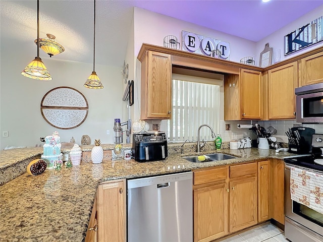 kitchen with light stone counters, backsplash, appliances with stainless steel finishes, decorative light fixtures, and sink