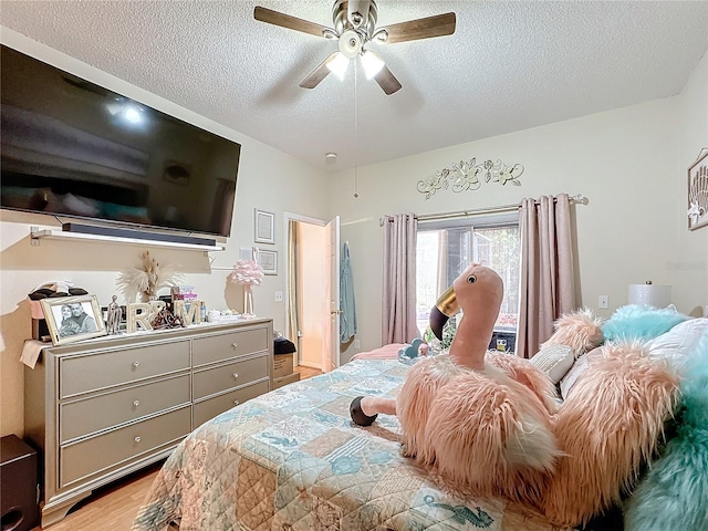 bedroom with a textured ceiling, light hardwood / wood-style flooring, and ceiling fan