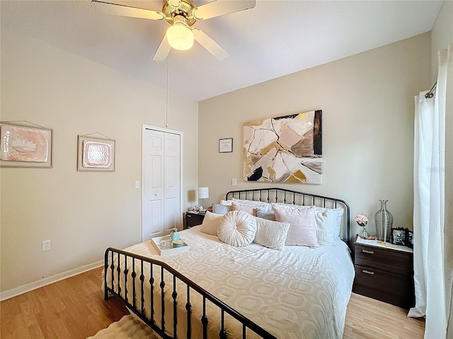 bedroom featuring light hardwood / wood-style floors, ceiling fan, and a closet