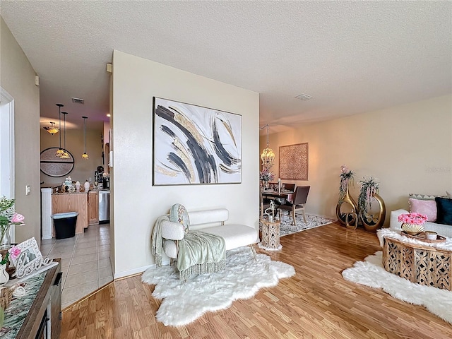 living area featuring a textured ceiling and light hardwood / wood-style flooring