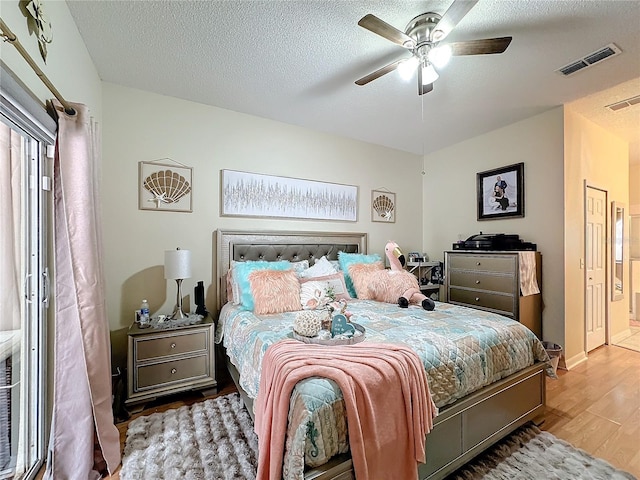 bedroom featuring a textured ceiling, hardwood / wood-style floors, and ceiling fan