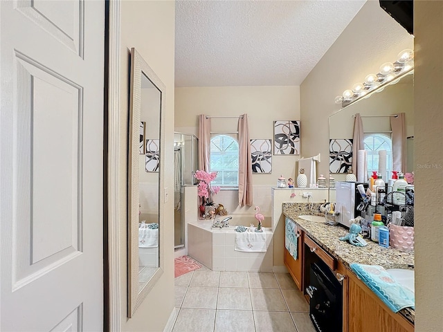 bathroom featuring vanity, plus walk in shower, a textured ceiling, and tile patterned flooring