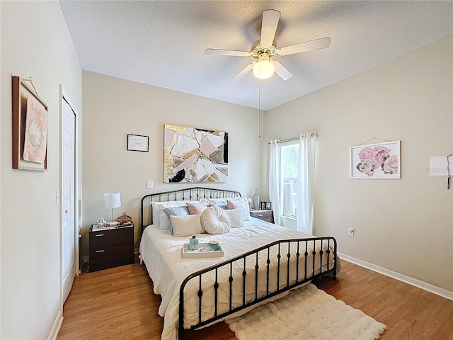 bedroom featuring a textured ceiling, hardwood / wood-style floors, and ceiling fan