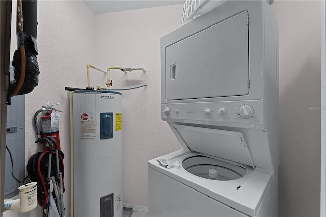 laundry room featuring stacked washer / drying machine and electric water heater