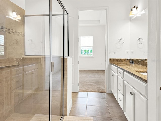 bathroom featuring vanity, a shower with shower door, and tile patterned flooring