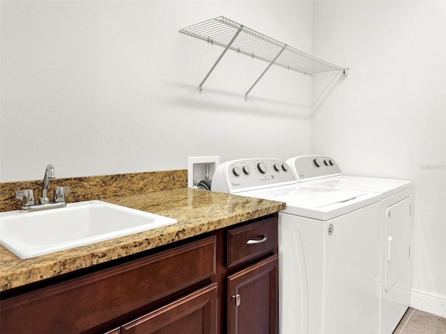 laundry area with washing machine and clothes dryer, light tile patterned flooring, cabinets, and sink