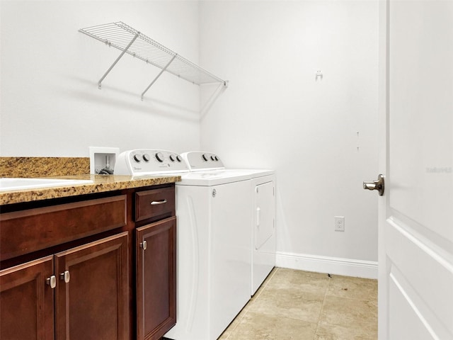 clothes washing area featuring cabinets and washer and clothes dryer