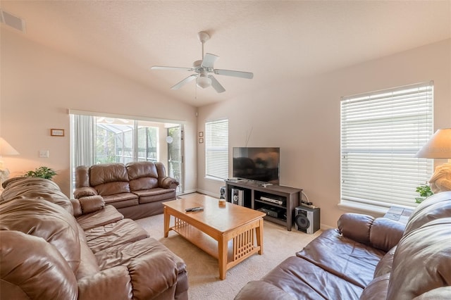 carpeted living room with ceiling fan and vaulted ceiling