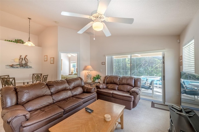 carpeted living room with a wealth of natural light, vaulted ceiling, ceiling fan, and a textured ceiling