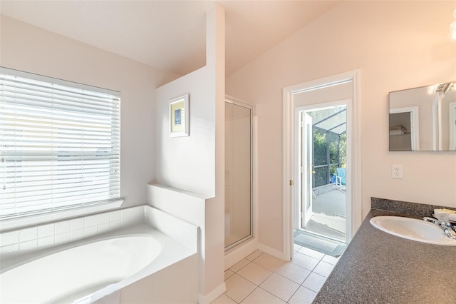 bathroom with vanity, vaulted ceiling, tile patterned floors, and separate shower and tub