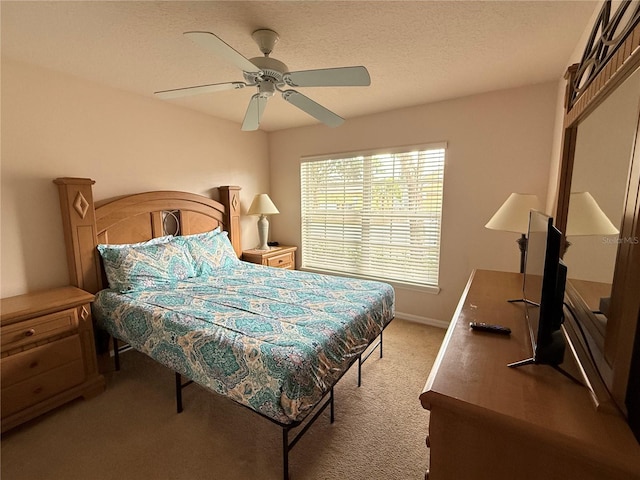 carpeted bedroom featuring a textured ceiling and ceiling fan