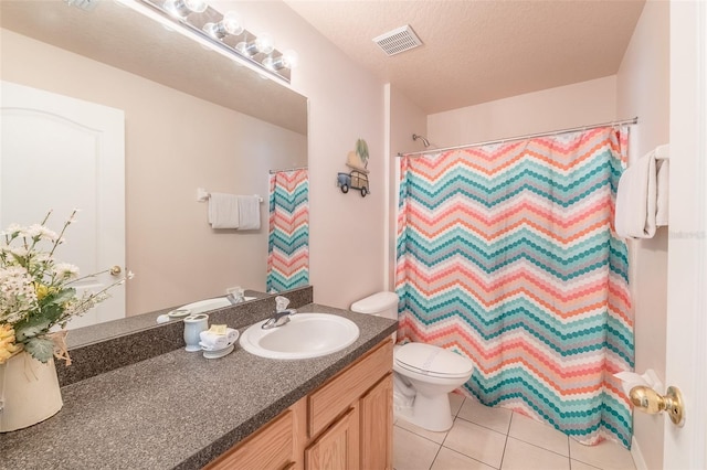 bathroom with toilet, tile patterned flooring, a textured ceiling, vanity, and walk in shower