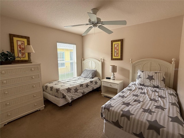 bedroom with a textured ceiling, dark colored carpet, and ceiling fan