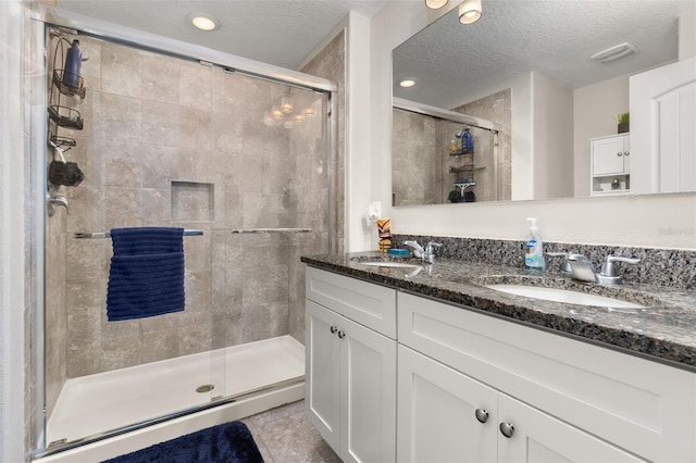 bathroom featuring a textured ceiling and a shower with door