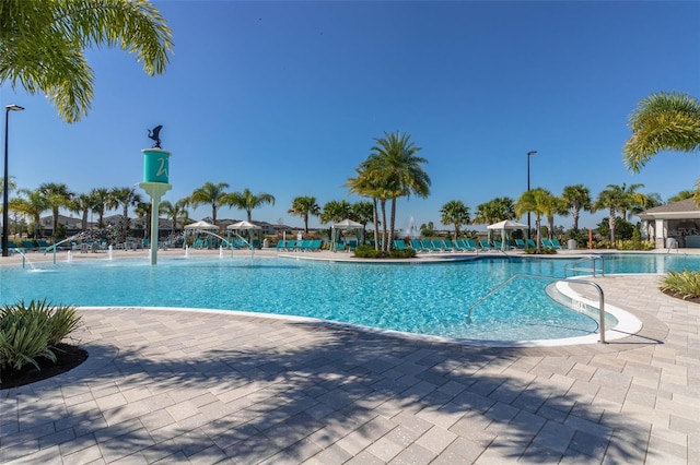 view of pool with pool water feature and a patio