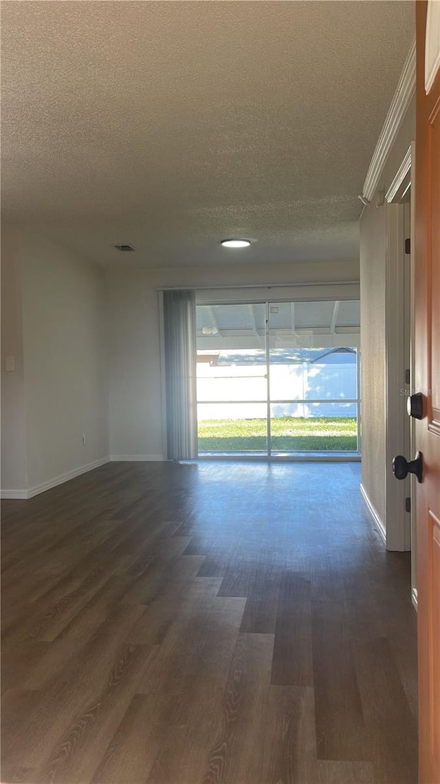 spare room with a textured ceiling and dark wood-type flooring