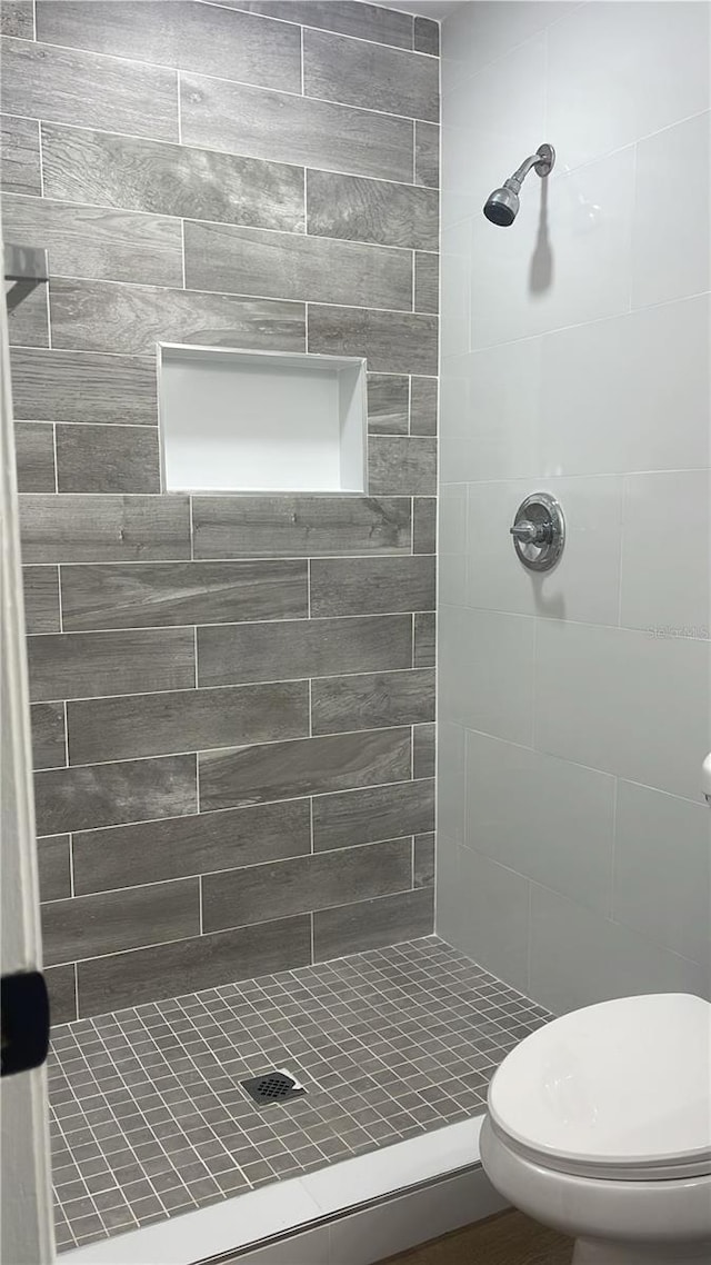 bathroom with toilet and tiled shower