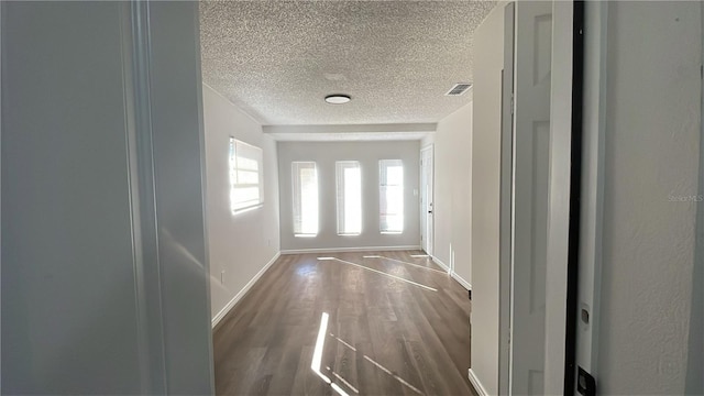 entryway featuring a textured ceiling and dark wood-type flooring