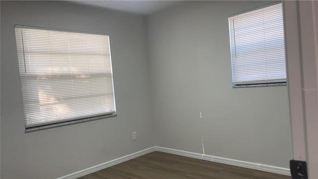 empty room with dark hardwood / wood-style flooring