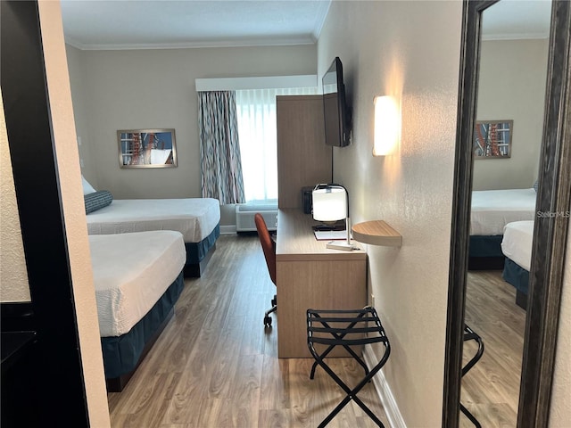 bedroom with hardwood / wood-style floors and crown molding