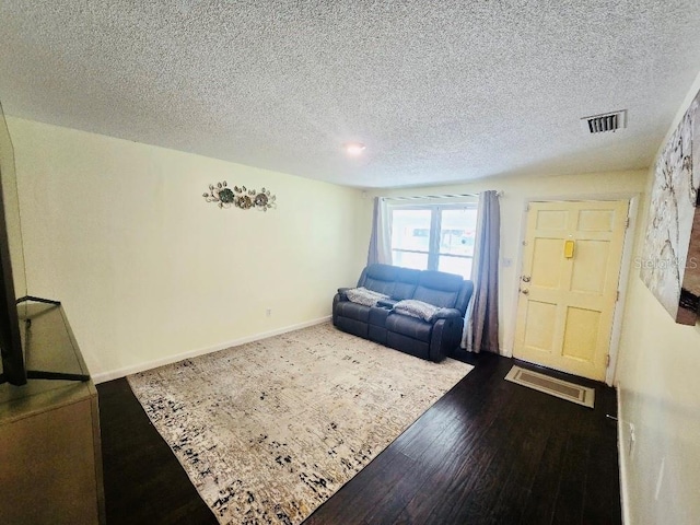 living room featuring wood-type flooring and a textured ceiling