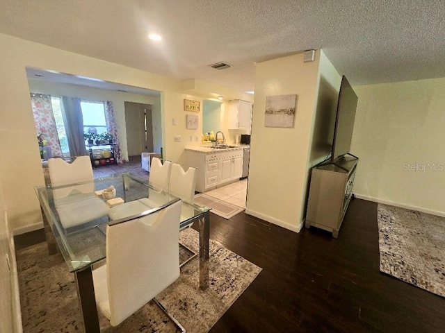 dining space with dark hardwood / wood-style floors and a textured ceiling