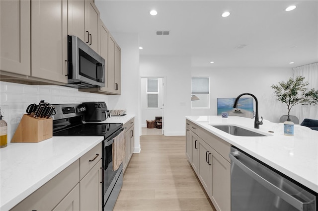 14442 Noto Ave, Clermont, FL 34714 - kitchen with stainless steel appliances, backsplash, light wood finished floors, light countertops, and recessed lighting