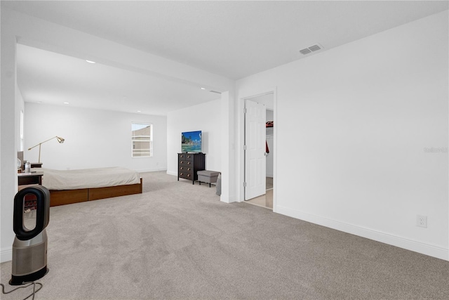 unfurnished bedroom featuring a walk in closet and light colored carpet