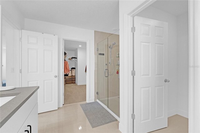 bathroom with vanity, tile patterned floors, and a shower with door