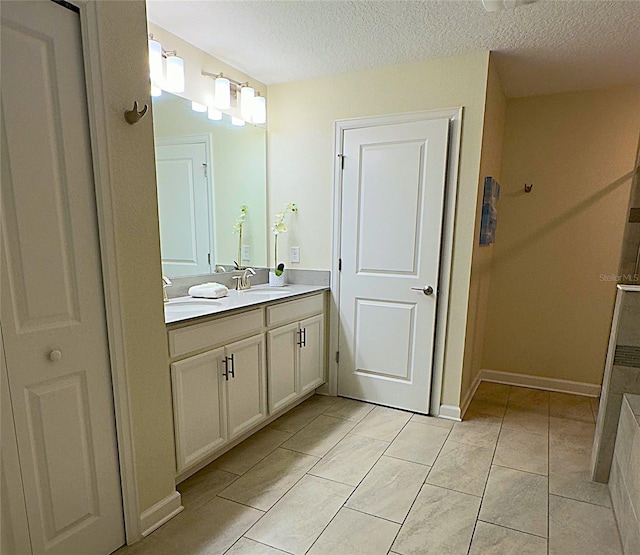 bathroom featuring tile patterned floors, vanity, and a textured ceiling