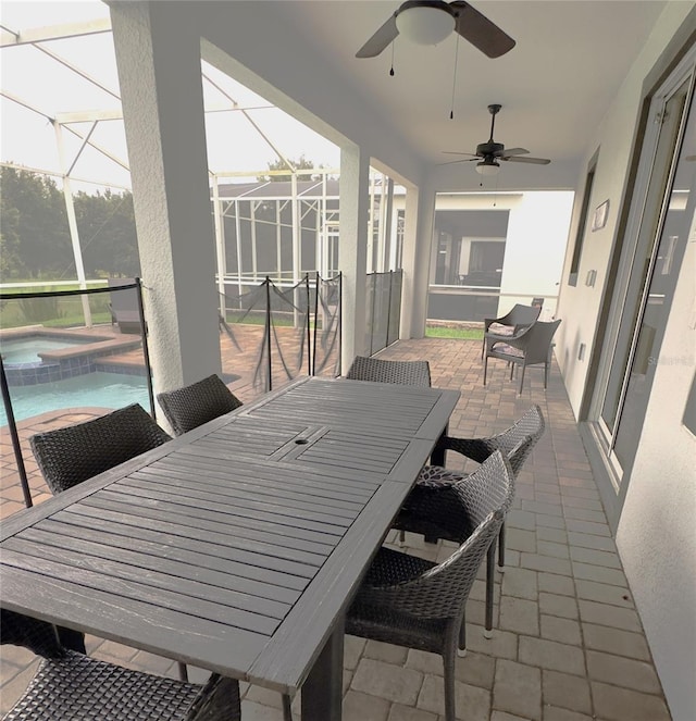 sunroom with ceiling fan and a swimming pool